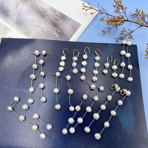 Macro shot of assorted baroque freshwater pearl drop earrings with gold chains