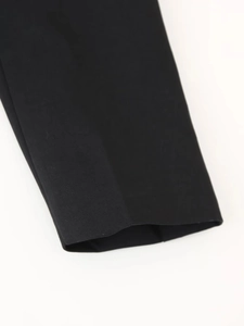 Détail de la texture du tissu noir et des coutures de finition sur la robe col en v