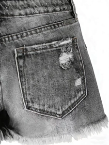 Close-up of distressed gray denim shorts with ripped back pocket and frayed hems