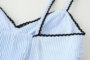 Nahaufnahme von blau-weiß gestreiftem Stoff mit schwarzer Häkelkante am Sommerkleid