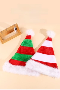 Detail of red and green striped plush elf hats with white pom-poms on a holiday desk