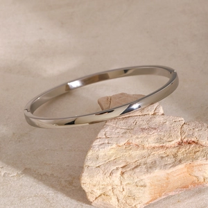 Makro-Detail des silbernen Edelstahl-Armreifs mit Spiegelglanz auf dem Stein