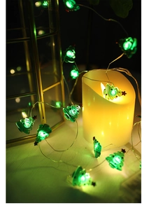 Close-up of warm green LED Christmas tree fairy lights on copper wire for festive decor