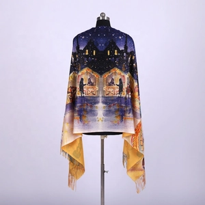 Close-up of soft cashmere-like shawl with colorful snowy village scene and tassel edges