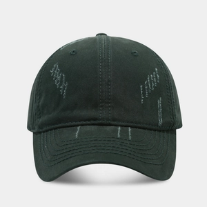 Detailed close-up of distressed cotton baseball cap showing heavy worn-out rip effects