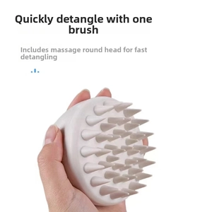 Detail of light grey scalp massage brush with round-tip bristles for hair detangling