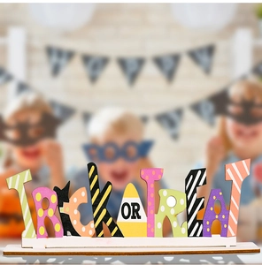Detail of wooden Trick or Treat tabletop sign with colorful patterns and candy corn motif
