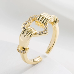 Macro shot of 18K gold plated heart ring with zircon stones on a white surface