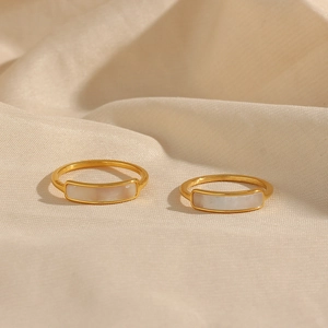 Minimalist 18K gold plated stainless steel rings with white rectangular stones on beige fabric