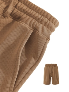 Detail of khaki men's drawstring shorts featuring breathable waffle knit texture and side pocket