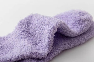 Detailed close-up showing soft purple coral fleece texture and plush fabric of the winter sock