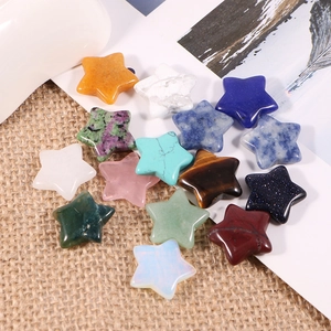Variety of 2cm natural gemstone star pendants in colorful crystals on linen background