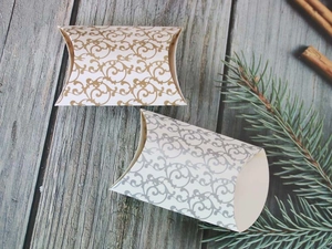 Detailed view of elegant gold and silver patterned pillow-shaped paper gift boxes