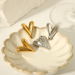 Elegant 18K gold and silver titanium steel heart earrings displayed on decorative stone
