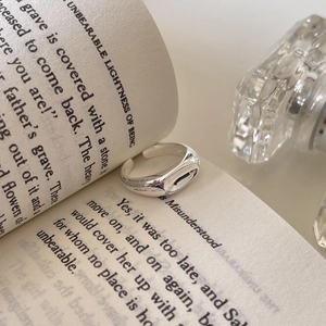 Adjustable minimalist 925 sterling silver signet ring placed on an open book