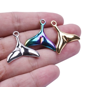 Hand holding three 304 stainless steel fishtail pendants in gold, silver and rainbow colors