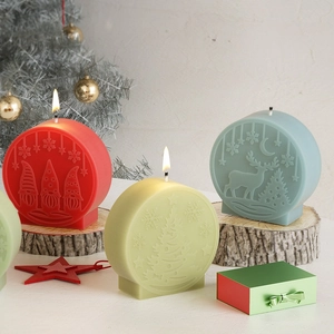Three Christmas embossed snowman scented candles on wood base with festive decor
