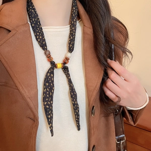 Macro shot of leopard print scarf necklace with colorful resin and wooden beads