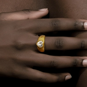 Macro detail of 18K gold plated heart zircon ring with unique textured ripple band