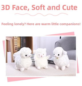 Detailed view of three white curly plush sheep toys with embroidered faces and golden bell