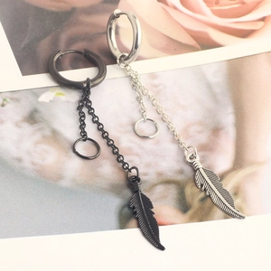 Punk feather drop earrings in black and silver finishes on a floral background