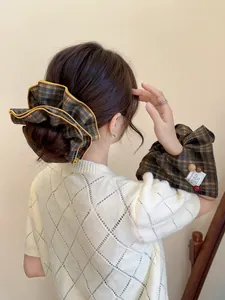Close-up of brown plaid fabric scrunchie on low ponytail with matching checkered sleeve covers