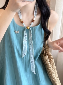 Close-up of floral print chiffon necklace with decorative wooden beads and acrylic accents.