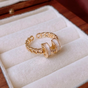 Close-up of a gold butterfly ring with white enamel and micro-pave crystals in a box