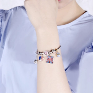 S925 silver charm bracelet with Union Jack heart and crown pendants on a model wrist