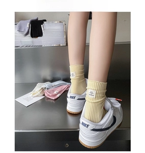 Détails de chaussettes en coton côtelé coloré avec étiquettes blanches en tons macarons