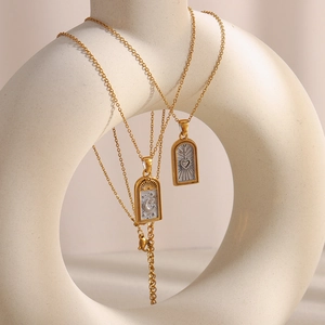 Colliers tarot en acier doré avec pendentifs lune et cœur sur un support chic
