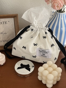 Minimalist white canvas tissue bag featuring black bow print and drawstring closure