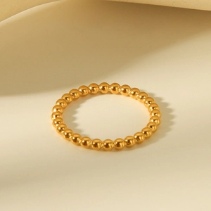 Minimalist gold beaded titanium steel ring with polished finish in warm scene