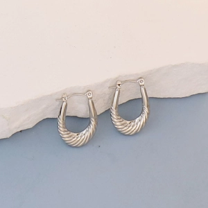 Detailed view of silver oval hoop earrings with spiral twisted texture for women