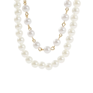 Close-up of dual-layer pearl necklace with golden metal links and white glossy beads