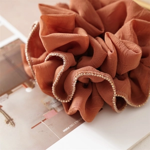 Orange ruffled fabric scrunchie hair tie with delicate gold bead edge detailing