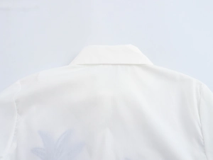 Detailed macro view of white shirt collar fabric texture and subtle blue embroidery
