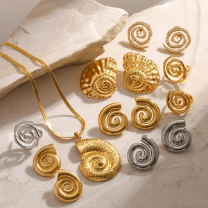 Elegant gold and silver conch jewelry set with pearls and zircons on a textured stone