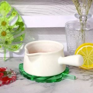 Detailed leaf-shaped resin coaster with embedded dried flowers on marble surface