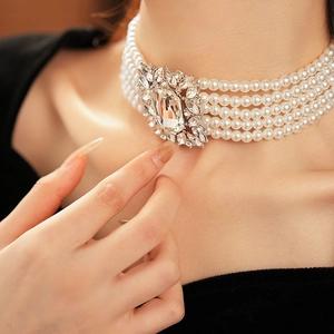 Close-up of five-layer pearl choker necklace featuring a central square crystal buckle