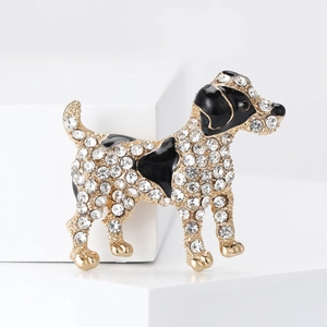 Detailed view of dog brooch featuring sparkling rhinestones and black enamel on gold metal