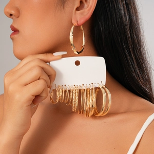 Close-up of sixteen assorted minimalist golden geometric and textured hoop earrings