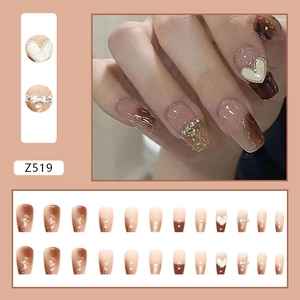 Caramel gradient press-on nails with golden heart charms and sparkling foil accents
