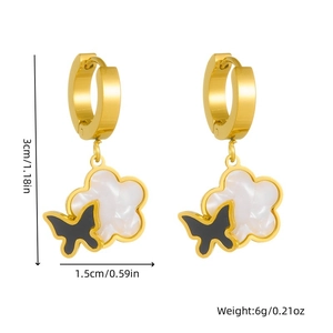 Gold hoop earrings with white cloud charms and black butterfly detail on white background