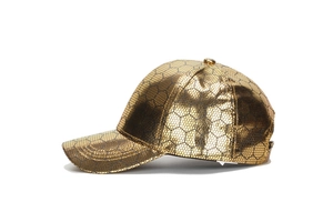 Close-up of golden PU leather baseball cap with black hexagonal honeycomb mesh texture