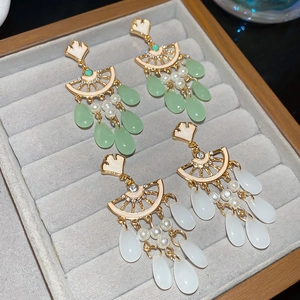 Detail of vintage fan-shaped tassel earrings with pearls and emerald green water drop charms