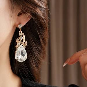 Gros plan d'élégantes boucles d'oreilles goutte d'or avec strass étincelants