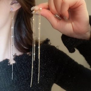 Detailed view of elegant long tassel earrings with micro-set zircons on silver pins