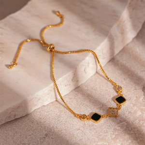 Vintage gold-plated adjustable bracelet featuring square black onyx and zircon charms