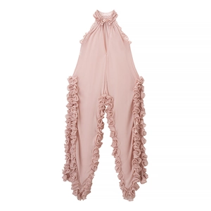 Detail view of pink chiffon romper with halter neck and ruffled edges on white backdrop
